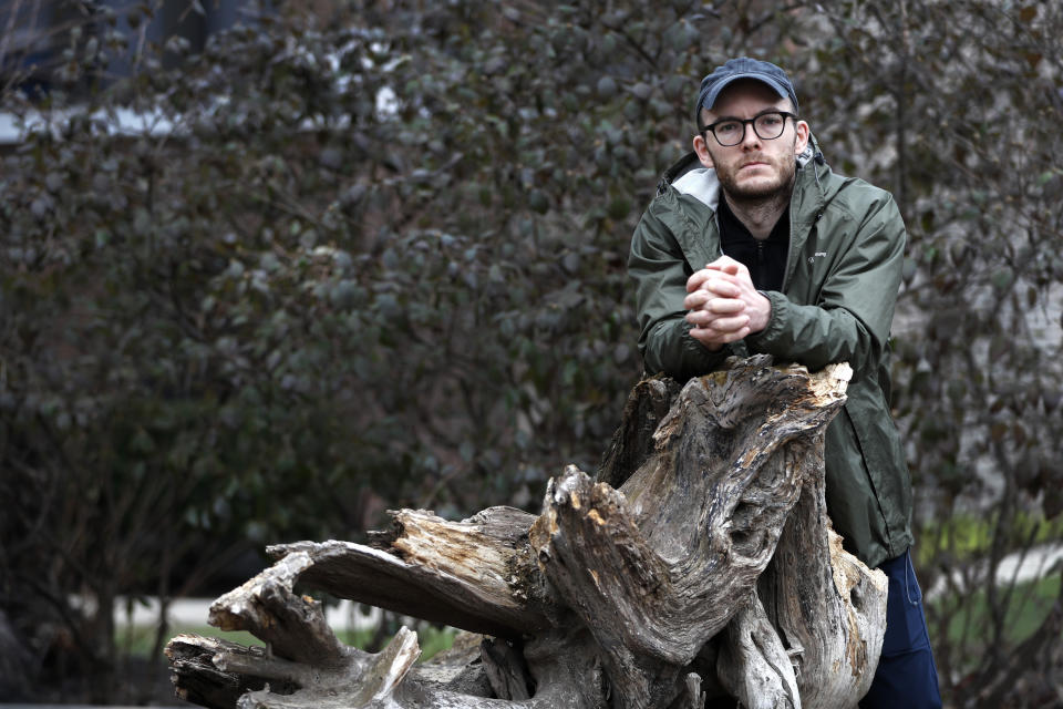 In this Monday, March 30, 2020, photo, Neal Miller poses for a portrait near where he is living during the COVID-19 outbreak in Chicago. Miller said his last stable job was as an adjunct professor at Loyola University in Chicago, sharing a house with four others to save money on rent. Now, all but one of the housemates are now out of work and decided this month to tell their own landlord that they couldn't pay on April 1. (AP Photo/Charles Rex Arbogast)