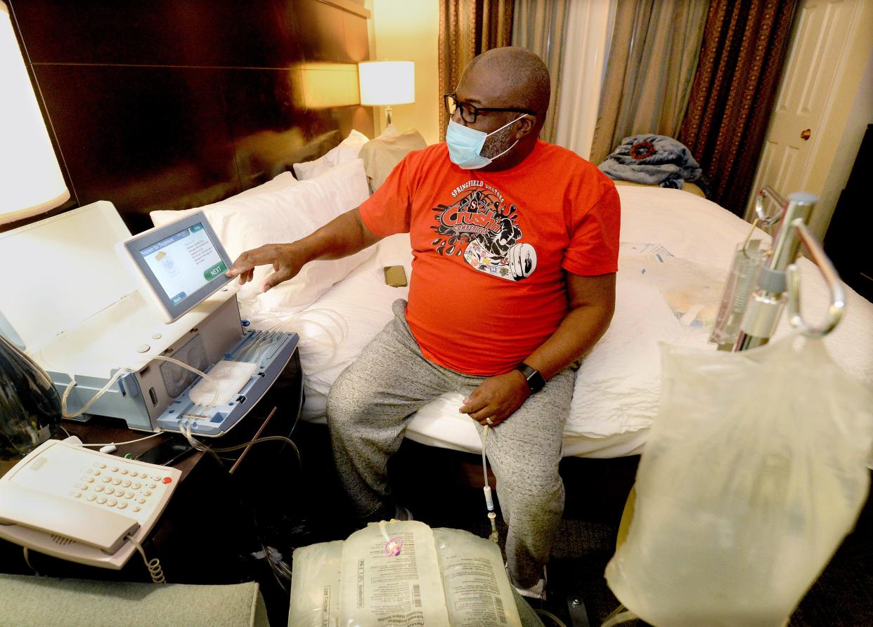 Ali Upshaw works to set up his dialysis machine for overnight treatment. Upshaw is an assistant basketball coach at Springfield High School and has been on home dialysis since February 2022. He's awaiting a kidney transplant.