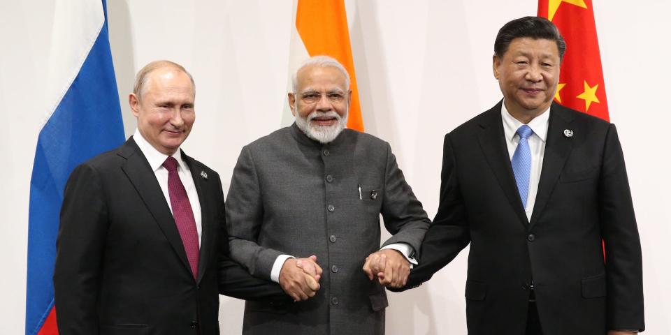 The leaders of India, Russia, and China holding hands and smiling