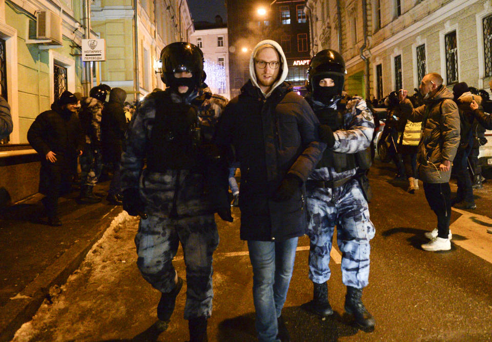 Police officers detain a Navalny supporter at the Red Square in Moscow, Russia, Tuesday, Feb. 2, 2021. A Moscow court has ordered Russian opposition leader Alexei Navalny to prison for more than 2 1/2 years on charges that he violated the terms of his probation while he was recuperating in Germany from nerve-agent poisoning. Navalny, who is the most prominent critic of President Vladimir Putin, had earlier denounced the proceedings as a vain attempt by the Kremlin to scare millions of Russians into submission. (AP Photo/Denis Kaminev)