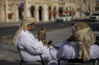 A man holds a falcon in a terrace of a bar in Doha, Qatar, Tuesday, Nov. 29, 2022. (AP Photo/Manu Fernandez)