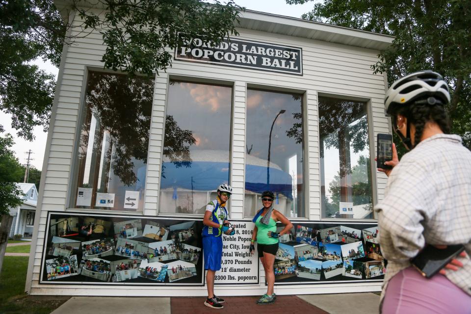 Melinda Ennis and her son Declan Ennis, 15, of Peoria, Illinois, get a photo with the world's largest popcorn ball as RAGBRAI rolls out of Sac City, Monday, July 26, 2021.