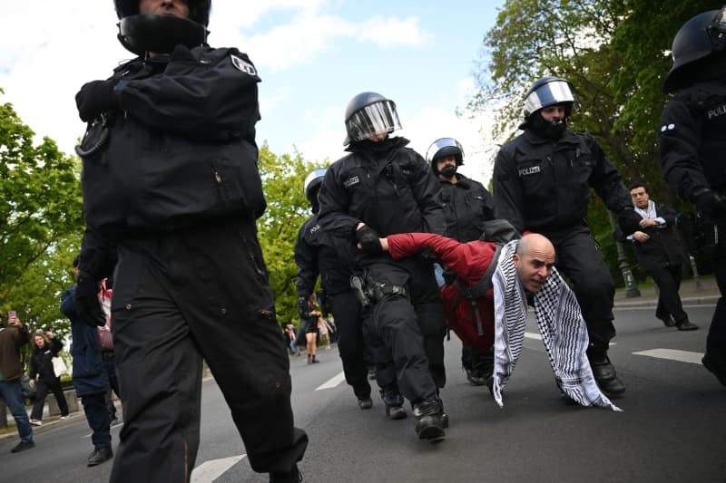 Police officers take away a participant in a dispersed support rally for the pro-Palestinian protest camp at the Federal Chancellery. Sebastian Gollnow/dpa