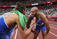 Lamont Marcell Jacobs of Italy is congratulated by teammate Gianmarco Tamberi after winning the final of the men's 100-meters at the 2020 Summer Olympics, Sunday, Aug. 1, 2021 in Tokyo, Japan. (Cameron Spencer/Pool Photo via AP)