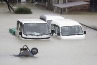 Cars sit submerged in water in the residential area hit by Typhoon Hagibis, in Ise, central Japan Saturday, Oct. 12, 2019. A heavy downpour and strong winds pounded Tokyo and surrounding areas on Saturday as a powerful typhoon forecast as the worst in six decades approached landfall, with streets and train stations deserted and shops shuttered.(Kyodo News via AP)