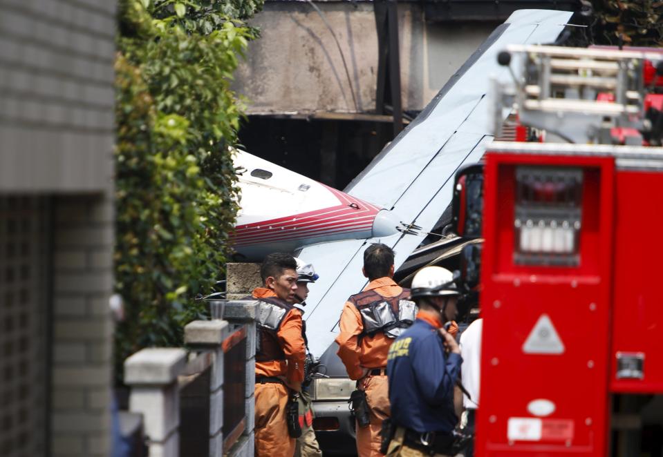 The tail section of a crashed light plane is seen after the plane went down in a residential area and burst into flames, in Chofu, outskirt of Tokyo