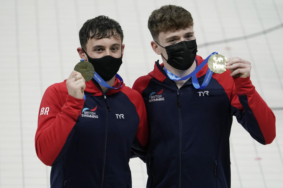 Matthew Lee, right, and Thomas Daley, left, of Britain pose with their gold medals after the men's synchronized 10-meter platform competition at the FINA Diving World Cup Saturday, May 1, 2021, at the Tokyo Aquatics Centre in Tokyo. (AP Photo/Eugene Hoshiko)