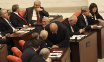 Nationalist lawmakers chat before Turkey's parliament authorized the deployment of troops to Libya to support the U.N.-backed government in Tripoli battle forces loyal to a rival government that is seeking to capture the capital, in Ankara, Turkey, Thursday, Jan. 2, 2020. Turkish lawmakers voted 325-184 at an emergency session in favor of a one-year mandate allowing the government to dispatch troops amid concerns that Turkish forces could aggravate the conflict in Libya and destabilize the region.(AP Photo/Burhan Ozbilici)