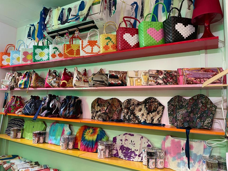 Shelves displaying bags, corsets, and other items made from textile wastes and excesses in the store.