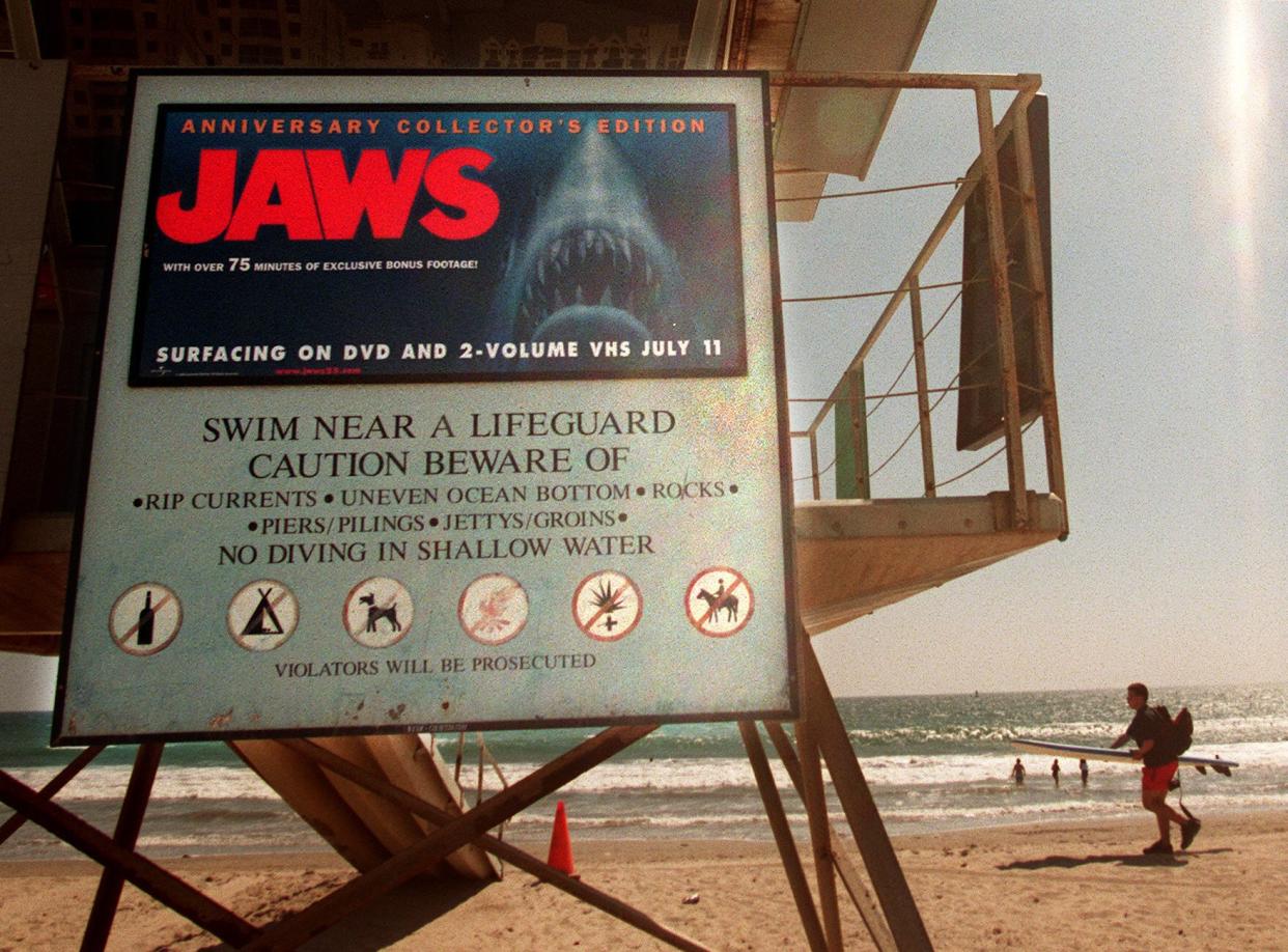 A beach ad on a lifeguard tower at Santa Monica Beach for the re-release of movie, "JAWS" is scaring children and foreign tourists from going into the water, but county officials say the ads are generating funds to maintain the beach.