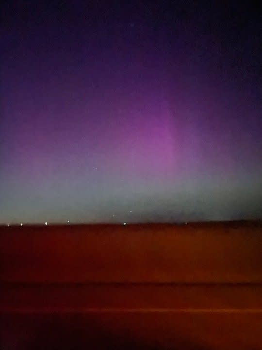Aurora borealis lights the night sky pink