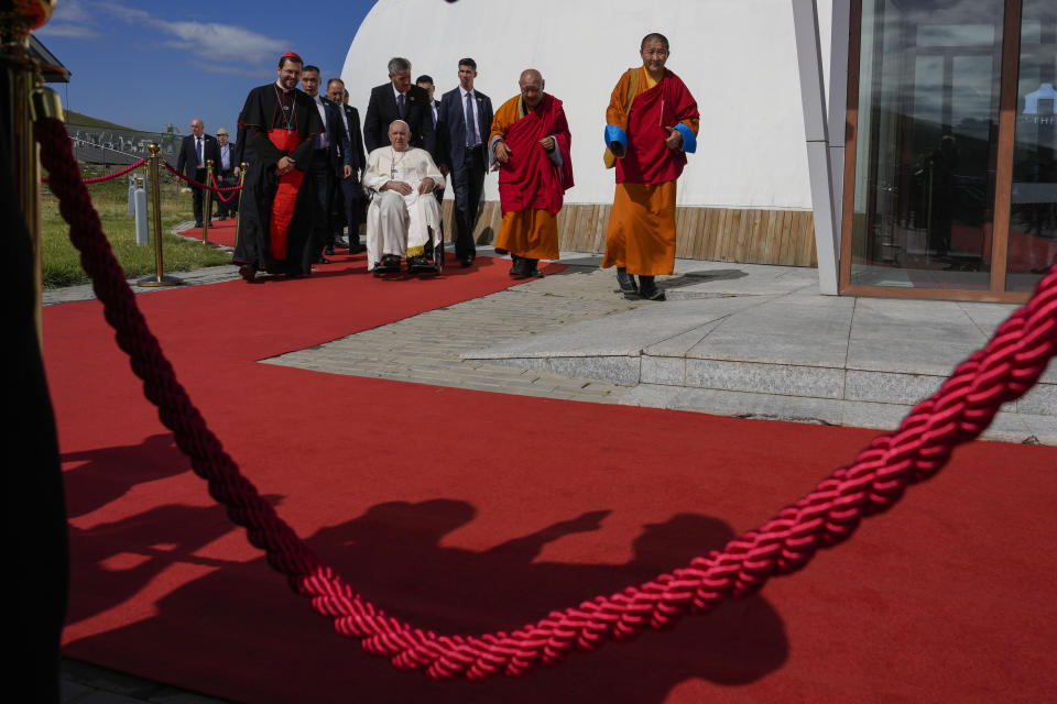 Pope Francis on a wheelchair leaves with Apostolic Prefect of Ulaanbaatar Cardinal Giorgio Marengo, left, and Gabju Demberel Choijamts, second from right, abbot of the Buddhists' Gandantegchinlen Monastery in Ulaanbaatarat, at the end of a meeting with religious leaders at the Hun Theatre some 15 kilometers south of the Mongolian capital Ulaanbaatar, Sunday, Sept. 3, 2023. Pope Francis has praised Mongolia's tradition of religious freedom dating to the times of founder Genghis Khan during the first-ever papal visit to the Asian nation. (AP Photo/Ng Han Guan)