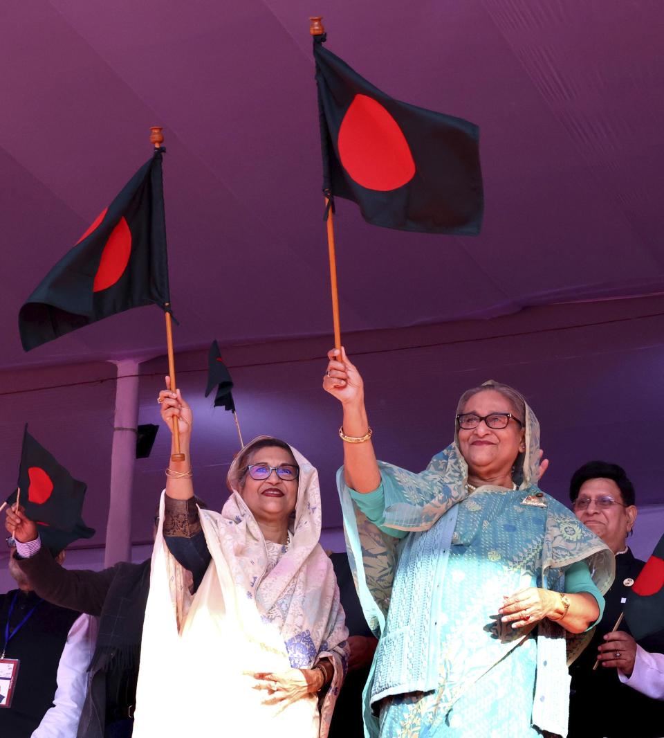 Bangladesh's Prime Minister Sheikh Hasina, right, waves the national flag during an election campaign rally for her ruling Awami League party, ahead of the upcoming national elections, in Sylhet, Bangladesh, Wednesday, Dec. 20, 2023. The country is gearing up for the Jan. 7 election, but opposition Bangladesh Nationalist Party led by former Prime Minister Khaleda Zia repeated its call on Wednesday to boycott the election. (AP Photo/Saiful Islam Kallal)