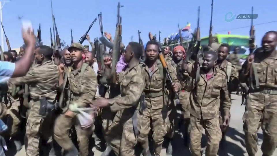 This image made from undated video released by the state-owned Ethiopian News Agency on Monday, Nov. 16, 2020 shows Ethiopian military cheering and dancing in front of cameras on a road in an area near the border of the Tigray and Amhara regions of Ethiopia. Ethiopia's prime minister Abiy Ahmed said in a social media post on Tuesday, Nov. 17, 2020 that "the final and crucial" military operation will launch in the coming days against the government of the country's rebellious northern Tigray region. (Ethiopian News Agency via AP)