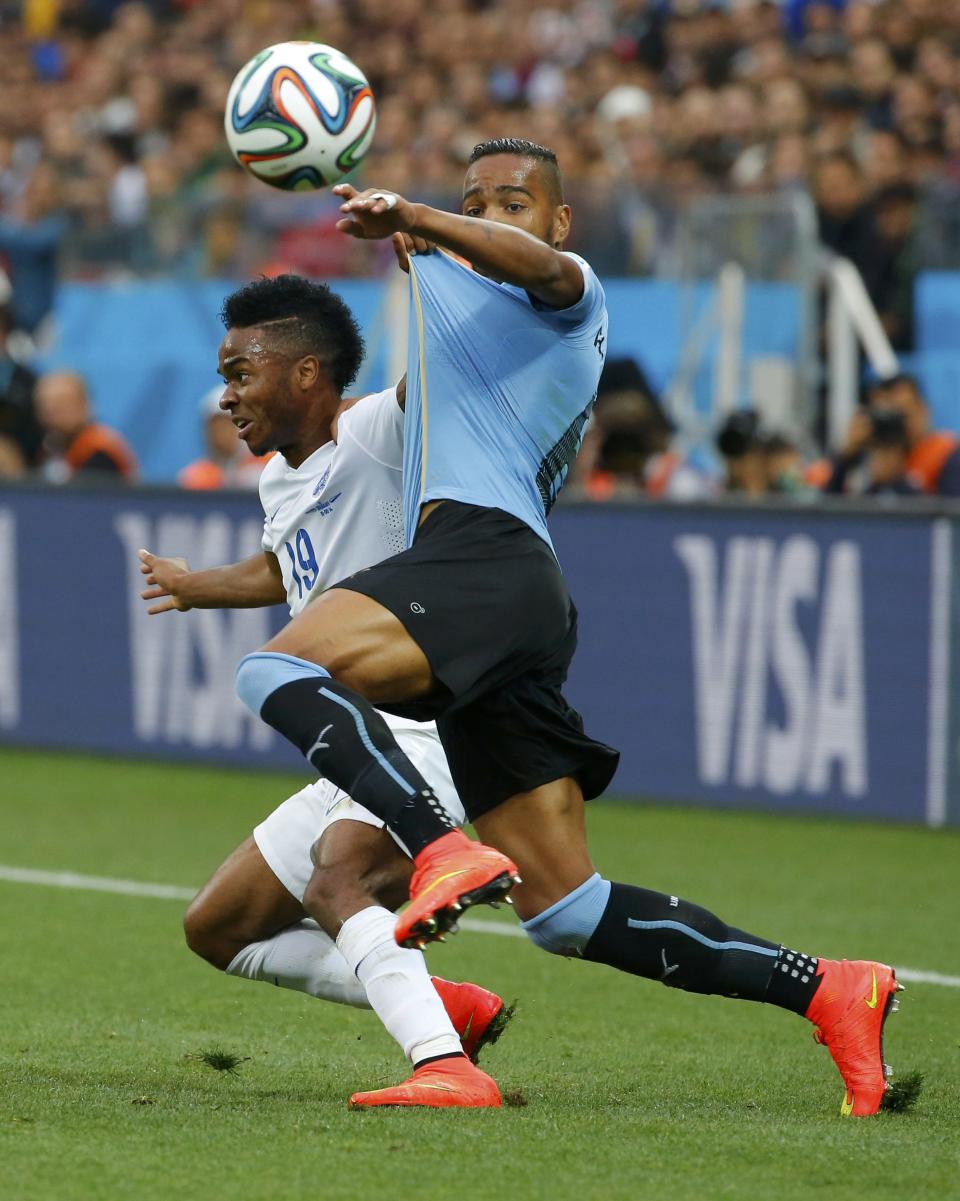 Uruguay's Pereira fights for the ball with England's Sterling during their 2014 World Cup Group D soccer match in Sao Paulo
