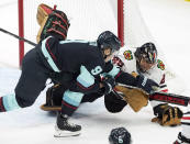 Chicago Blackhawks goaltender Marc-Andre Fleury, right, traps the puck as Seattle Kraken center Ryan Donato (9) closes in during the first period of an NHL hockey game, Monday, Jan. 17, 2022, in Seattle. (AP Photo/Ted S. Warren)