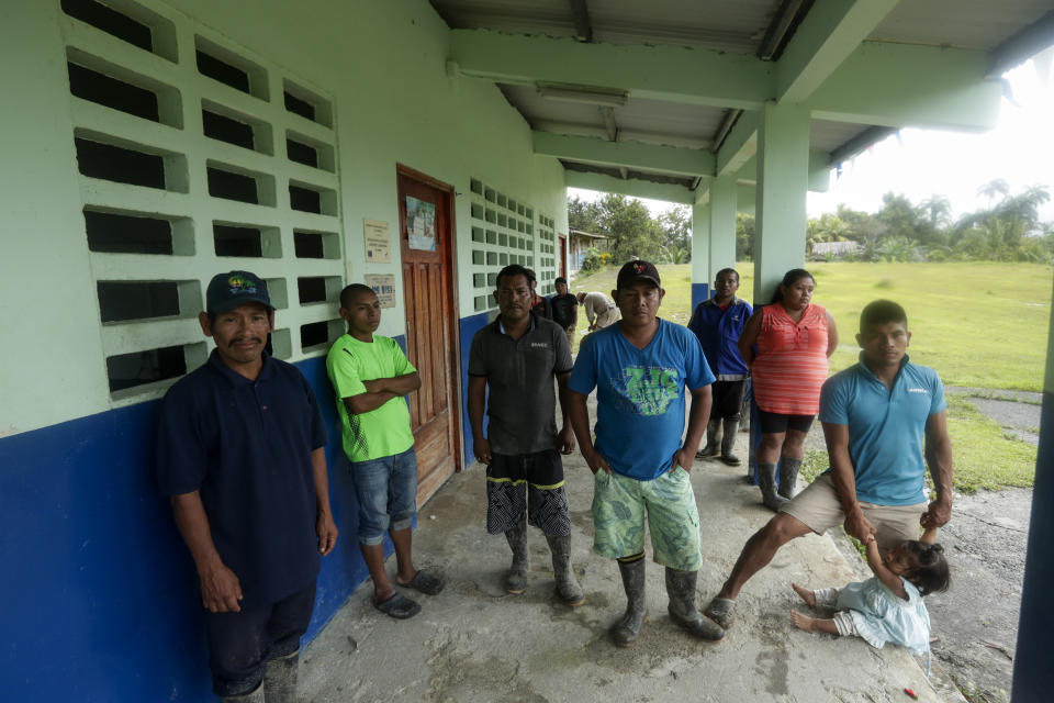 Residents gather at a school in the jungle community of El Terron, Panama, Friday, Jan. 17, 2020. A pregnant woman, five of her children and a neighbor where round on up by about 10 lay preachers at the remote hamlet on Jan. 13 and tortured, beaten, burned and hacked with machetes to make them "repent their sins", authorities said. (AP Photo/Arnulfo Franco)