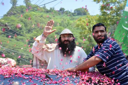 Syed Salahuddin (L), Supreme Commander of Hizbul Mujahideen, is showered with flower petals as he arrives to speak at a news conference in Muzaffarabad, Pakistan July 1, 2017. REUTERS/M. Saif-ul-Islam