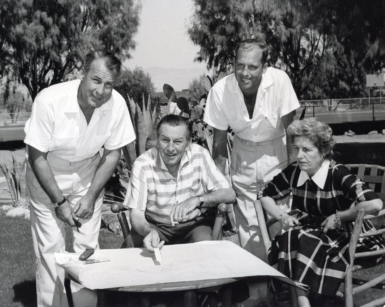 Walt and Lilly Disney peruse architect Carl Denny's plans for their second home at Smoke Tree Ranch in Palm Springs with builder Bill Foster.