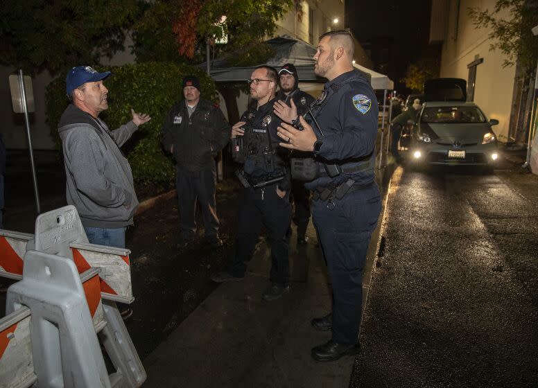 REDDING, CA-NOVEMBER 8, 2022: Richard Gallardo, left, a candidate for the Shasta County Board of Education, is told by members of the Redding police dept. that he is not allowed to walk into an alley to observe ballots being delivered to the Shasta County Clerk & Elections office in Redding because a temporary permit was obtained closing off the alley to members of the public. (Mel Melcon / Los Angeles Times)