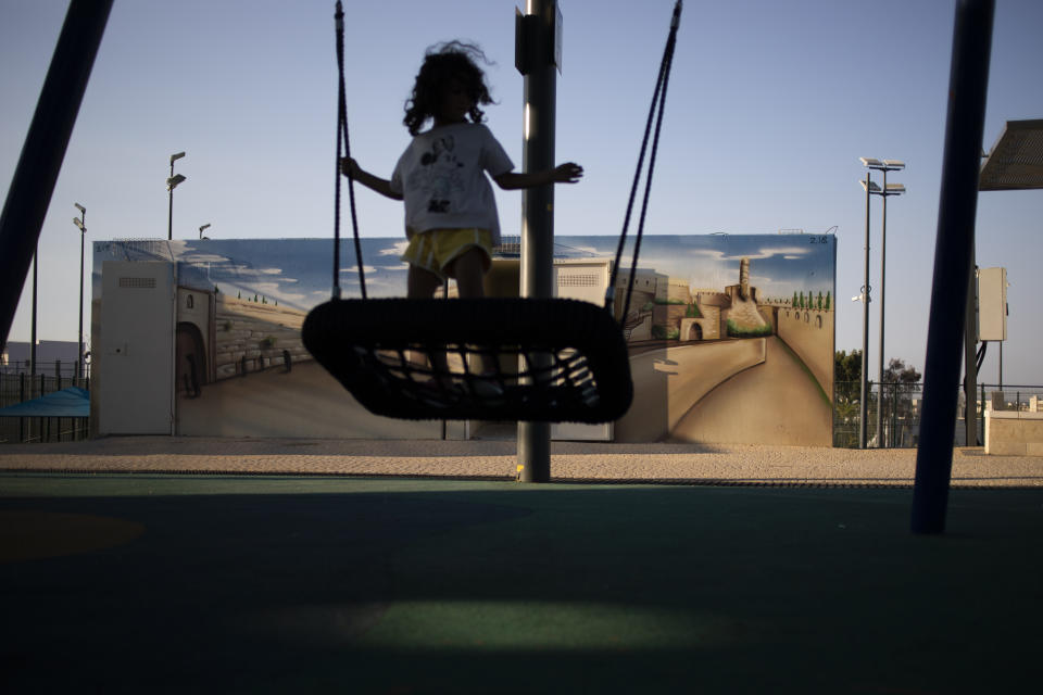 A girl swings next to a painted concrete bomb shelter, at a public park in Sderot, Israel, Aug. 2, 2021.No place in Israel has been hit harder by Palestinian rocket fire than Sderot, a working-class town just about a mile (1.5 kilometers) from the Gaza border. Although Sderot is enjoying an economic boom and revival, a generation of children and parents are suffering from the traumatic effects of two decades of rocket fire that experts are still struggling to understand. (AP Photo/Ariel Schalit)