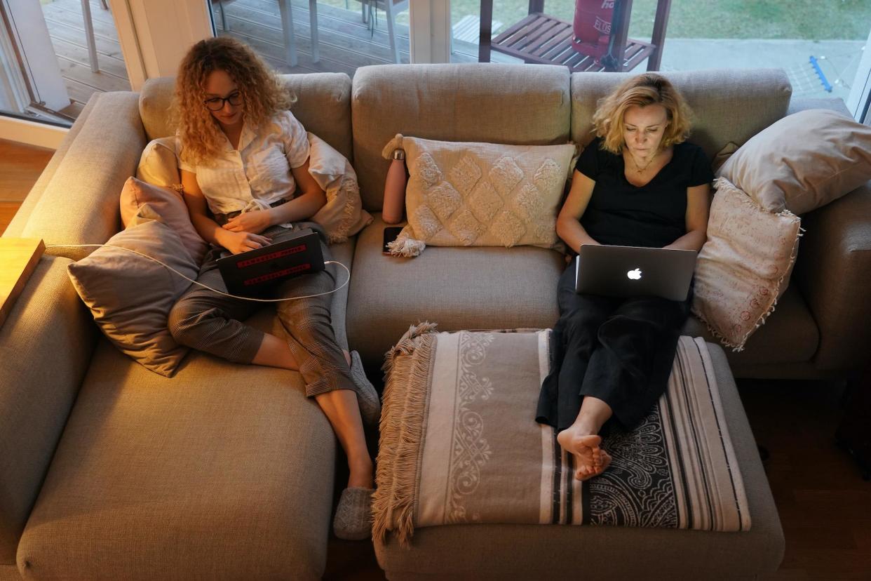 A mother, who is temporarily working from home, and her daughter, home after her university was temporarily closed, sit on a couch at their laptop computers at their home during the coronavirus crisis on March 28 in Berlin, Germany: Sean Gallup/Getty Images