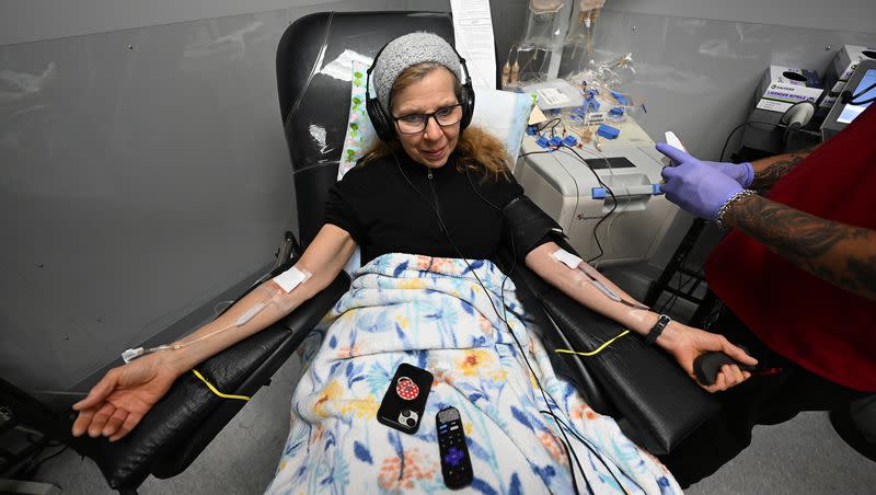 Jill Baker watches a movie as collection specialist Jonathan Guillen assists her with her blood donation at the American Red Cross location in Murray, on Jan. 8, 2024.