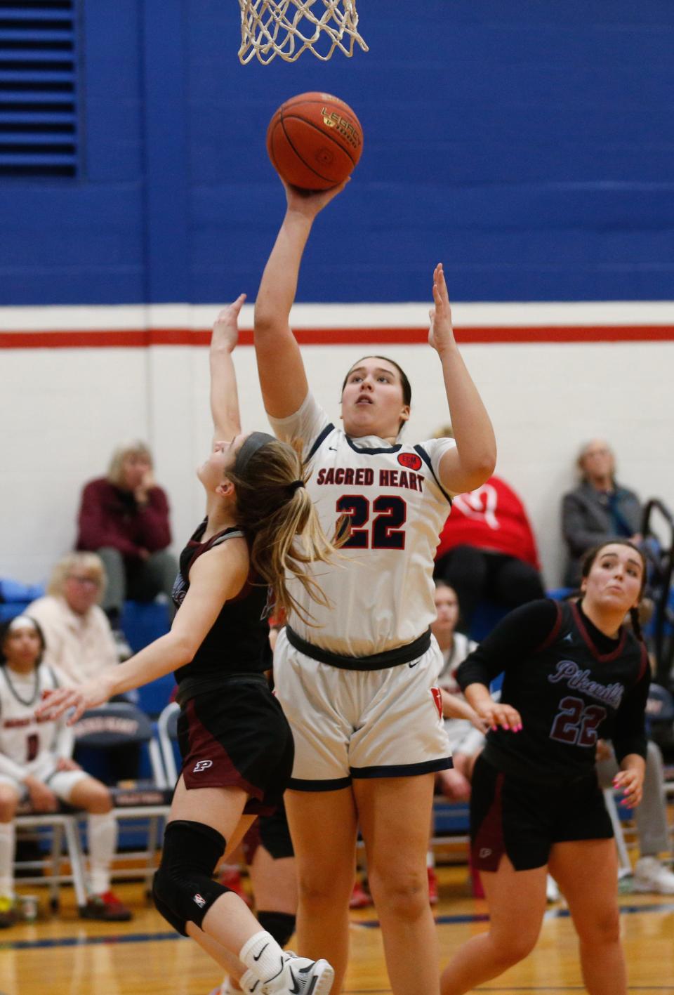 Sacred Heart’s Angelina Pelayo makes the basket against Pikeville’s Kristen Whited Saturday afternoon in Louisville.