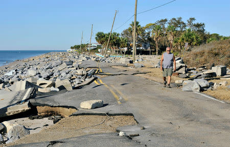 Mike Lester walks along the washed out road in front of his home on the Gulf of Mexico in the aftermath of Hurricane Michael at Alligator Point in Franklin County, Florida, U.S., October 13, 2018. REUTERS/Steve Nesius