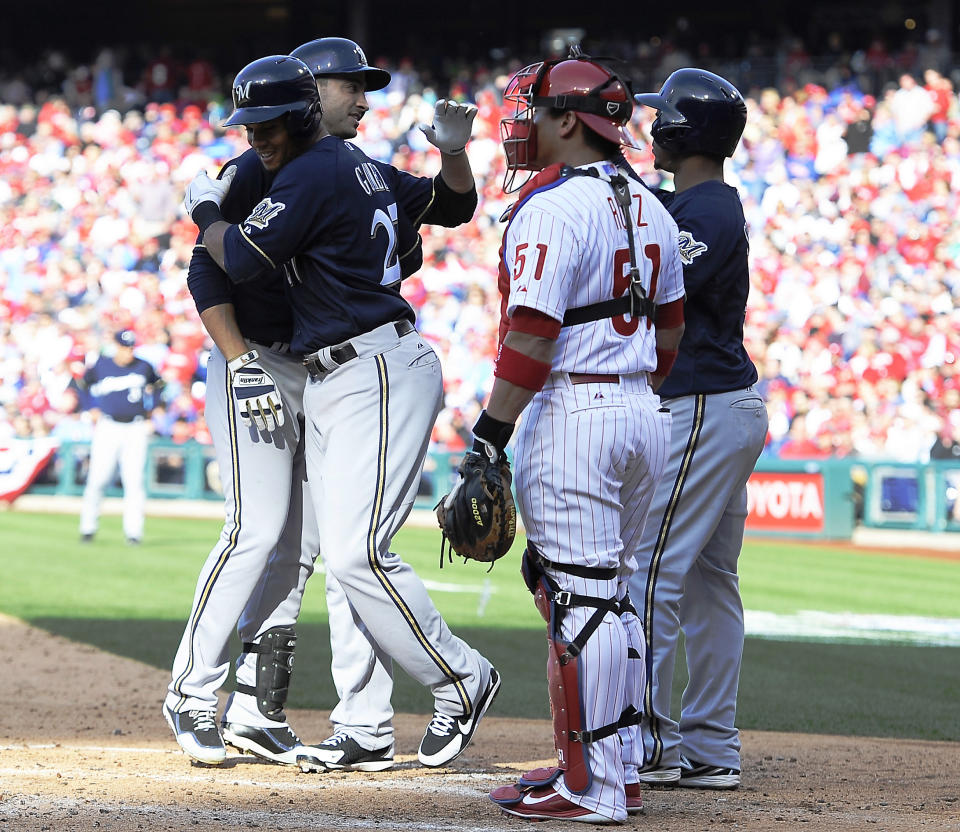 Philadelphia Phillies' catcher Carlos Ruiz (51) watches Milwaukee Brewers' Ryan Braun, left, celebrate with Carlos Gomez, middle, and Jean Segura, right, after hitting a three run homer in the third inning of an MLB National League baseball game on Tuesday, April 8, 2014, in Philadelphia. (AP Photo/Michael Perez)