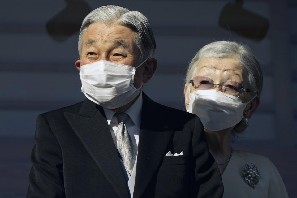 Japan's Emperor emeritus Akihito and Empress emerita Michiko greet well-wishers through a bullet-proof glass from a balcony during their New Year's public appearance at the Imperial Palace in Tokyo Monday, Jan. 2, 2023. The annual celebration returned after a two-year hiatus for coronavirus restrictions. (Franck Robichon/Pool Photo via AP)