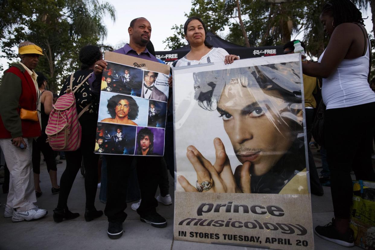 Mandatory Credit: Photo by Eugene Garcia/EPA/Shutterstock (7935307a)Mourners Hold Signs Adorned with Pictures of the Musician Prince During a Vigil in Los Angeles California 21 April 2016 American Singer-songwriter and Musician Prince a Multi-talented Artist who Produced a String of Genre-fusing Hits in the 1980s Died on 21 April at His Residence in Chanhassen Minnesota He was 57 United States Los AngelesUsa People Prince Obit - Apr 2016.