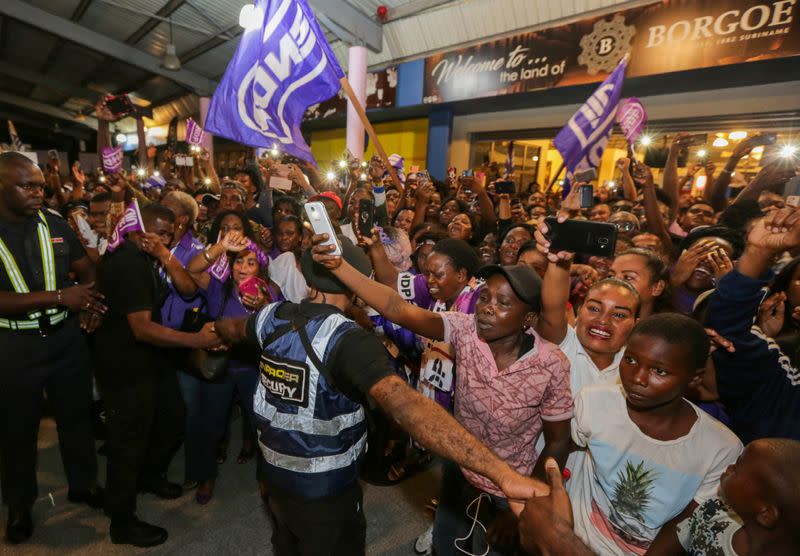 Supporters of Suriname's President Desi Bouterse (not pictured), who was convicted of murder for the execution of opponents by a court in Suriname, cheer upon his arrival from China, in Paramaribo