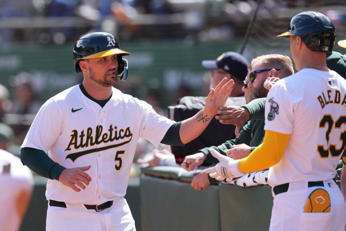 Oakland Athletics third baseman J.D. Davis (5) is congratulated by teammates after scoring a run against the Cleveland Guardians during the second inning at Oakland-Alameda County Coliseum on March 30, 2024. Darren Yamashita/Darren Yamashita