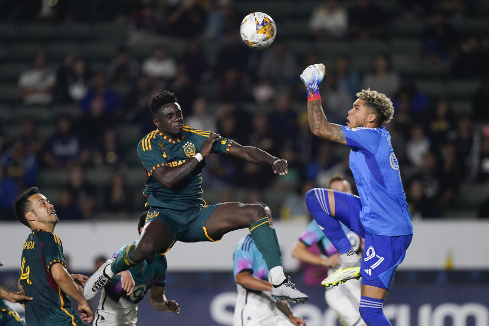 LA Galaxy defender Chris Mavinga, left, jumps for the ball next to Minnesota United goalkeeper Dayne St. Clair during the first half of an MLS soccer match Wednesday, Sept. 20, 2023, in Carson, Calif. (AP Photo/Ryan Sun)