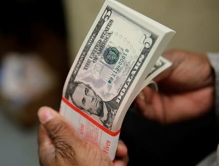 FILE PHOTO: A packet of U.S. five-dollar bills is inspected at the Bureau of Engraving and Printing in Washington