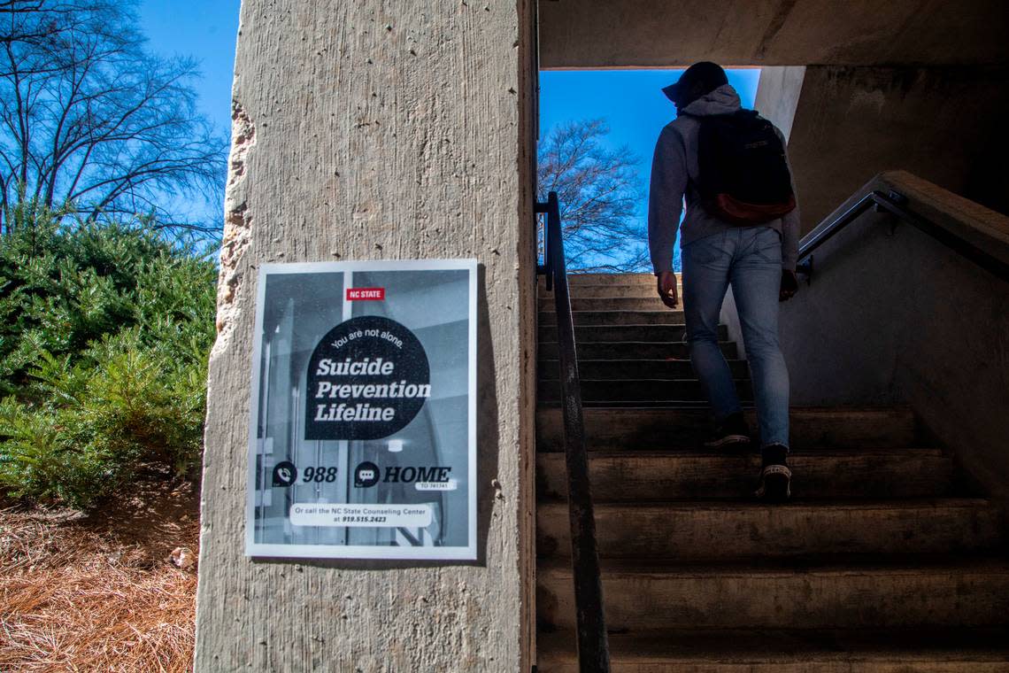 Signs, like this one in a parking deck stairwell on N.C. State’s main campus, advertise a suicide prevention help Monday, Feb. 13, 2022.