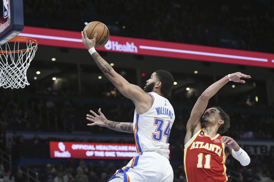 Oklahoma City Thunder forward Kenrich Williams (34) goes up for a shot past Atlanta Hawks guard Trae Young (11) in the second half of an NBA basketball game, Wednesday, Jan. 25, 2023, in Oklahoma City. (AP Photo/Kyle Phillips)