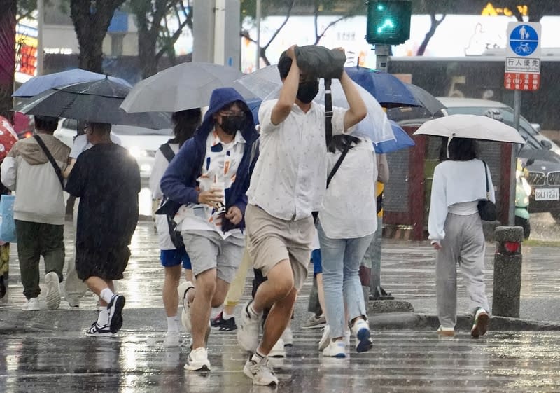 鋒面影響  高雄傍晚下起陣雨（1） 受鋒面影響，高雄地區24日傍晚雲層密布、下起陣 雨，有民眾未備雨具出門，先以隨身物品遮擋雨勢、 快步通過馬路。 中央社記者董俊志攝  113年4月24日 