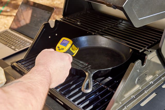 <p>People / Russell Kilgore</p> A tester checking the heat of a cast iron pan on a gas grill