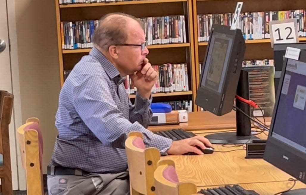 A man works at a computer inside the DeSoto County Library, where access to the internet is a lifeline to many residents. For "some of them, this is the only place they have to come," DeSoto County librarian Linda Waters said.