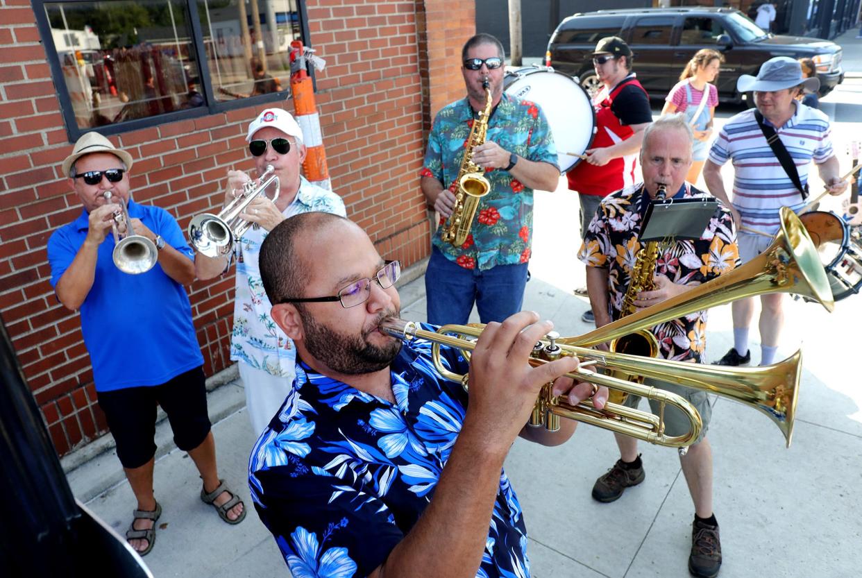 Musical director Martin Williams, center foreground, plays his double-bell trumpet along with the other members of the NACHO Street Band during the Avenue for All festival in 2021 on Parsons Avenue. NACHO is short for Nationwide Children's Hospital Orchestra.