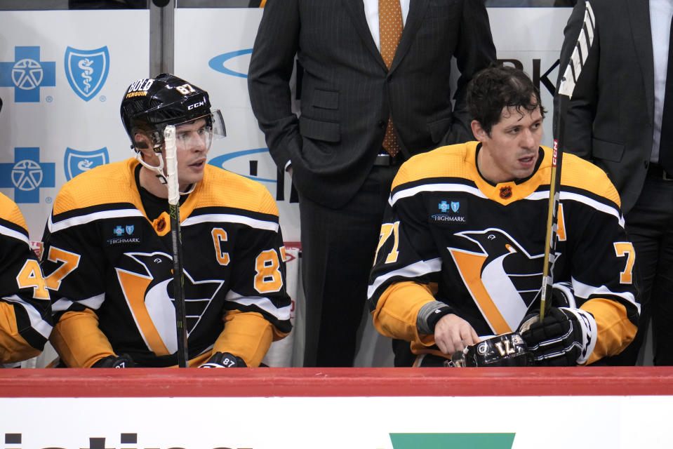 Pittsburgh Penguins' Sidney Crosby (87) and Evgeni Malkin (71) sit on the bench during the first period of the team's NHL hockey game against the Vancouver Canucks in Pittsburgh, Tuesday, Jan. 10, 2023. The Penguins won 5-4. (AP Photo/Gene J. Puskar)