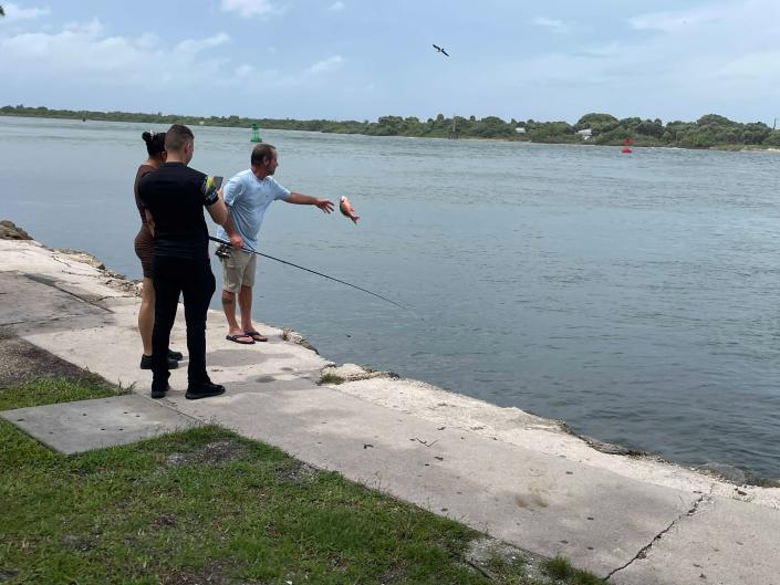 Tommy Ballard, of Fort Pierce, throws a fish back into the water at the Fort Pierce Inlet during a break in the rain from Hurricane Ian's effects on the Treasure Coast Sept. 28, 2022.