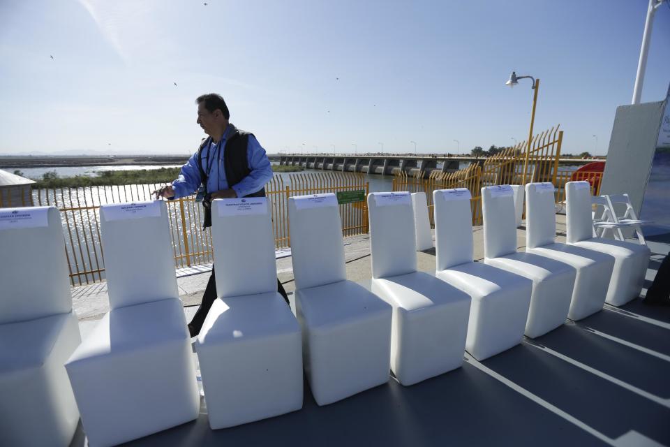 A Mexican official counts the chairs for visiting dignitaries shortly before a ceremony to mark the climax of a Colorado River water pulse event Thursday, March 27, 2014, Los Algodones, Mexico. Colorado River water has begun pouring over a barren delta near the U.S.-Mexico border, the result of a landmark bi-national agreement being celebrated Thursday. (AP Photo/Gregory Bull)