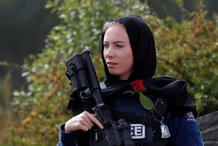 A policewoman is seen as people attend the burial ceremony of a victim of the mosque attacks, at the Memorial Park Cemetery in Christchurch, New Zealand March 21, 2019. REUTERS/Jorge Silva