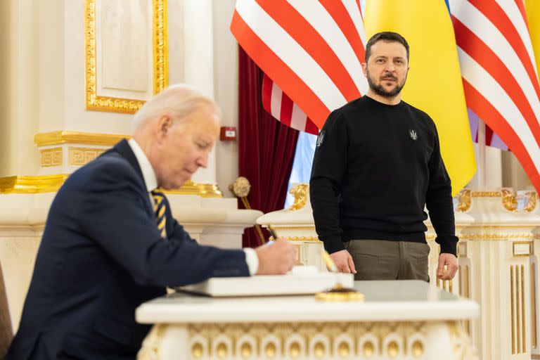 El presidente ucraniano Volodymyr Zelensky (R) observa cómo el presidente estadounidense Joe Biden firma el libro de invitados en el Palacio Presidencial antes de su reunión.