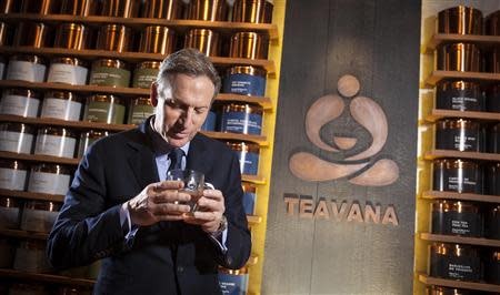 Howard Schultz, chief executive of Starbucks, smells a cup of tea as he poses for a portrait at his new Teavana store in New York, October 23, 2013. REUTERS/Carlo Allegri