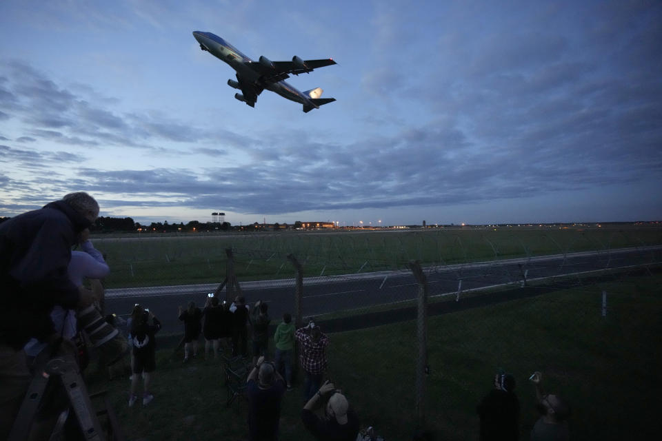 People watch Air Force One, carrying U.S. President Joe Biden and first lady Jill Biden, take off from RAF Mildenhall, near Bury St. Edmunds, in eastern England, to go to Cornwall for the G7 summit, Wednesday, June 9, 2021. (AP Photo/Matt Dunham)