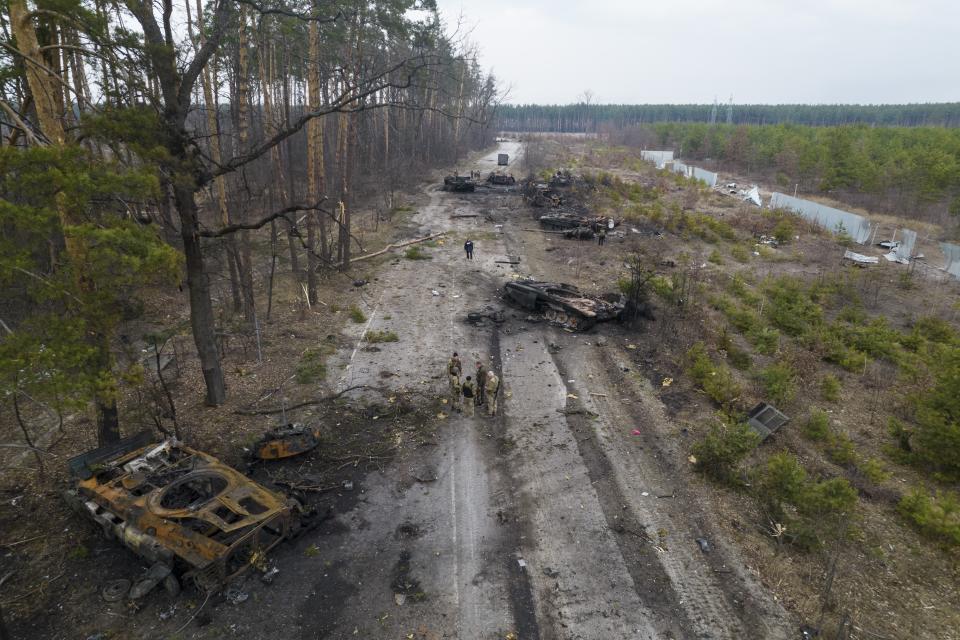 Archivo - Soldados ucranianos en medio de vehículos blindados rusos destruidos en las afueras de Kiev, Ucrania, el 31 de marzo de 2022. El presidente ruso, Vladimir Putin, quien comenzó la guerra el 24 de febrero de 2022 y podría terminarla en cualquier momento, todavía parece decidido a pelear hasta el final, sin piedad y a toda costa. (AP Foto/Rodrigo Abd, Archivo)